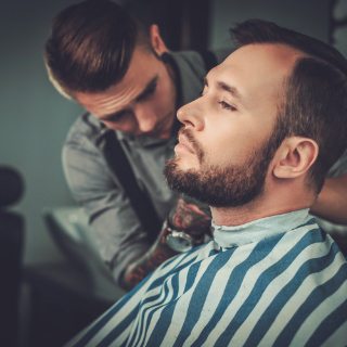 demo-attachment-148-confident-man-visiting-hairstylist-in-barber-shop-PR3JT7K